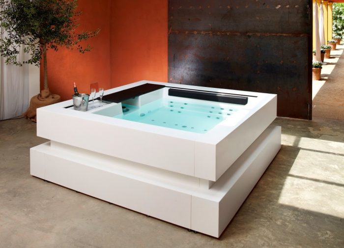 Witte moderne whirlpool met champagne en champagneglazen op de rand