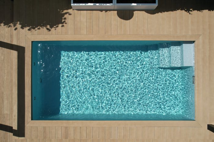 Bouwkundig zwembad met houten vlonder